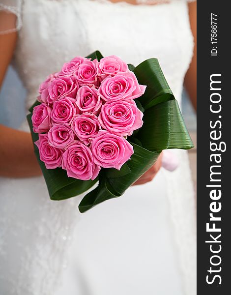 Bride holding pink roses bouquet close-up. Bride holding pink roses bouquet close-up