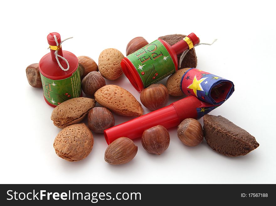 Mixed nuts with party blowers and poppers on a plain white background.