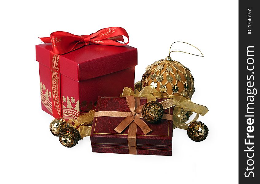 Red gift box with a satiny bow against gold Christmas-tree decorations