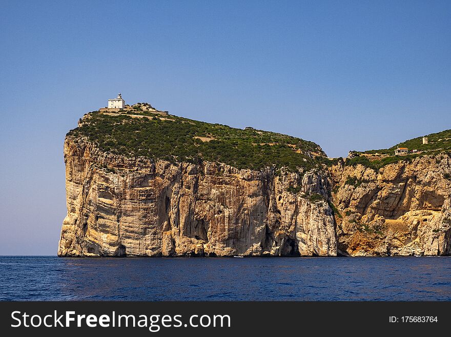 Alghero, Sardinia / Italy - 2018/08/09: Faro di Capo Caccia lighthouse at the limestone cliffs of the Capo Caccia cape at the Gulf of Alghero
