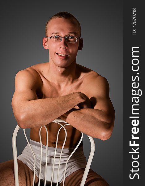 Muscular man sitting on a chair