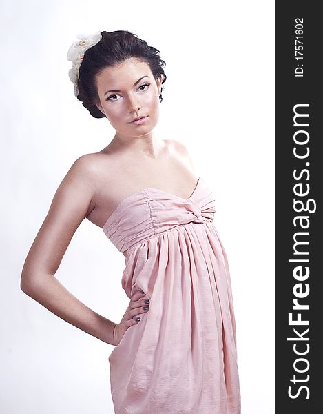 Charming young girl in pink dress in studio