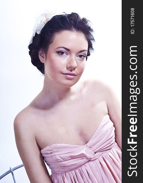 Studio portrait of a tender charming young girl in pink dress