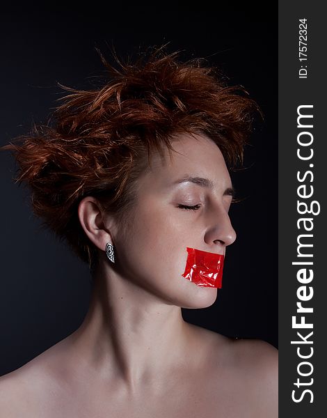 The red girl with closed eyes, the mouth is closed by a red sticky tape