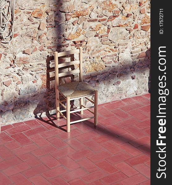 Cross - shaped shadow on the chair over stone wall photo