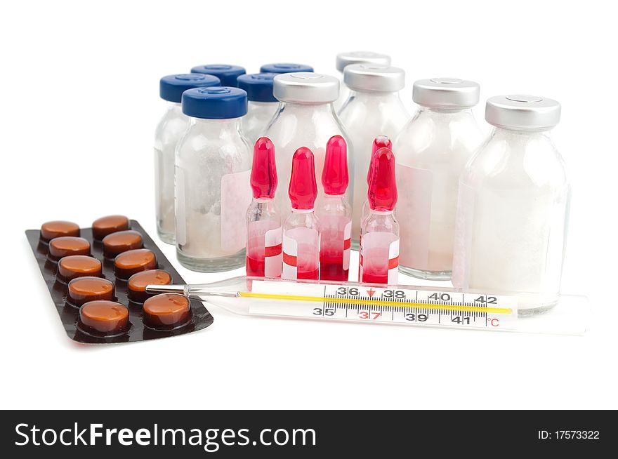 Ampoule, a thermometer and pills on a white background