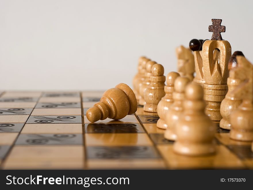 Figures of chess on the chessboard on the white background. Figures of chess on the chessboard on the white background