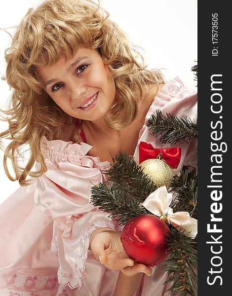 Pretty girl stand near a Christmas tree with christmas balls. Isolated over white background