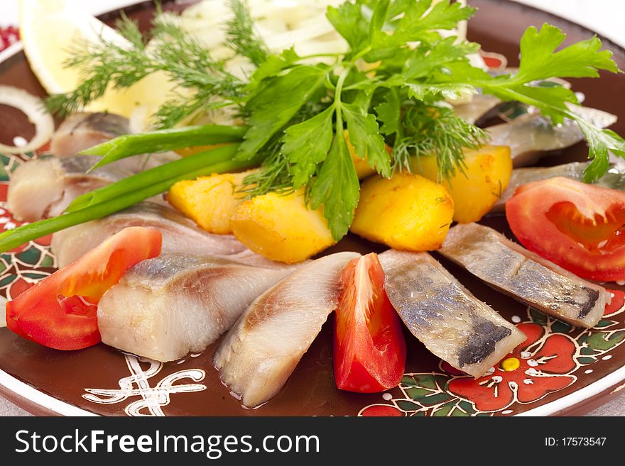 Herring with baked potato and tomatos Close-up