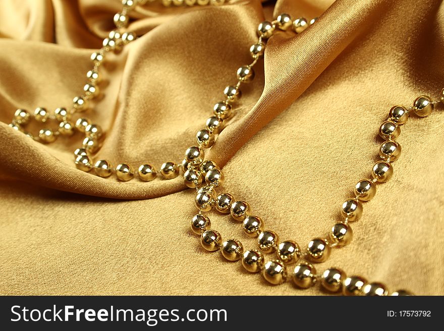 Background of gold cloth on which lay the golden beads. Background of gold cloth on which lay the golden beads