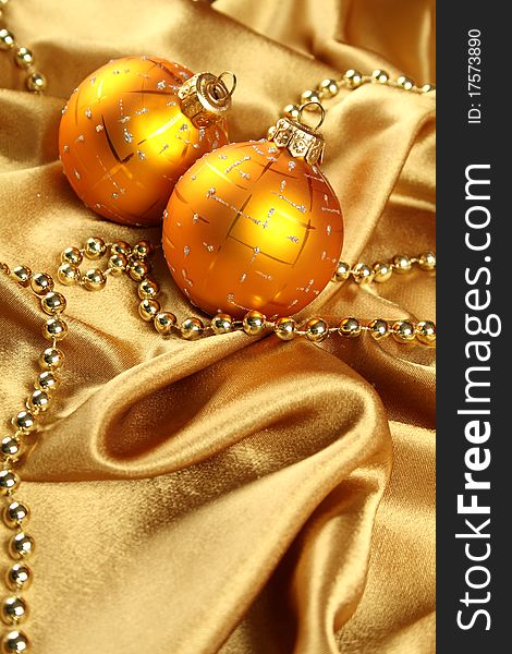 On gold fabric are gold ornaments and Christmas balls of yellow. Background. On gold fabric are gold ornaments and Christmas balls of yellow. Background