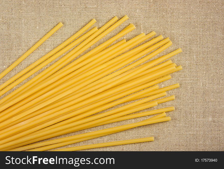 Raw spaghetti on the burlap background