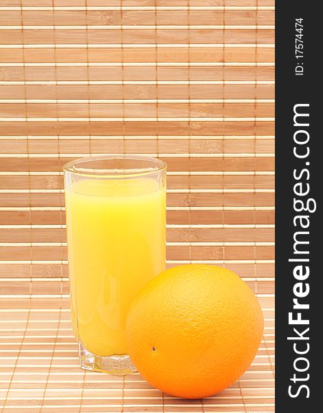 Orange juice in a glass and an orange