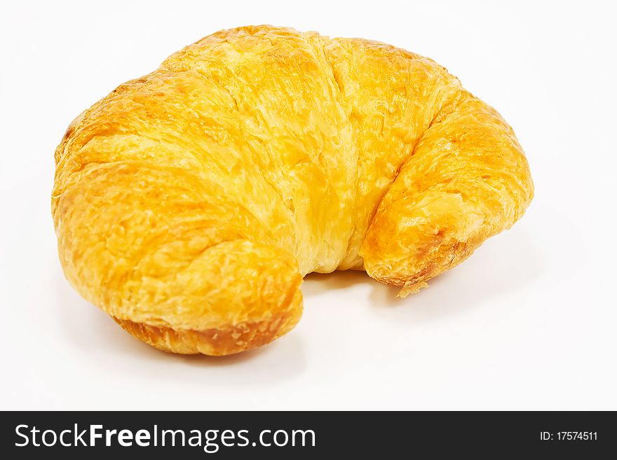 Single fresh croissant, casting soft whadow on white. Delicious!