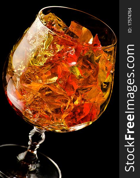 Glass filled with jelly on black background