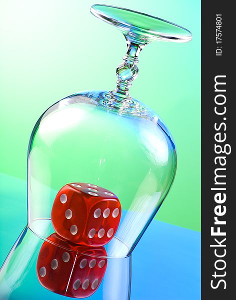 Red dice covered by transparent snifter. Red dice covered by transparent snifter
