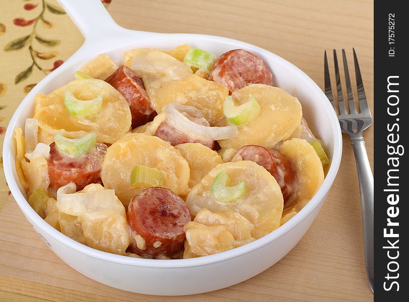 Baking dish of au gratin potatoes and Italian sausage. Baking dish of au gratin potatoes and Italian sausage