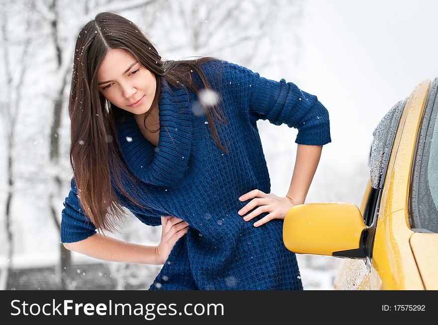 Attractive brunette young woman near the yellow car