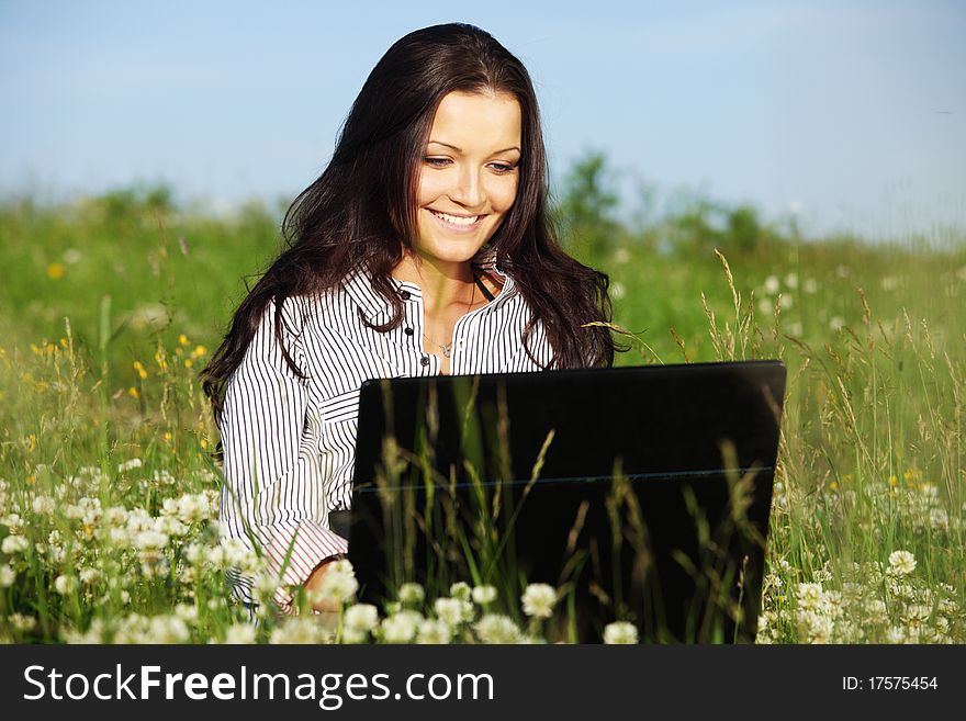 Girl with laptop on green grass. Girl with laptop on green grass