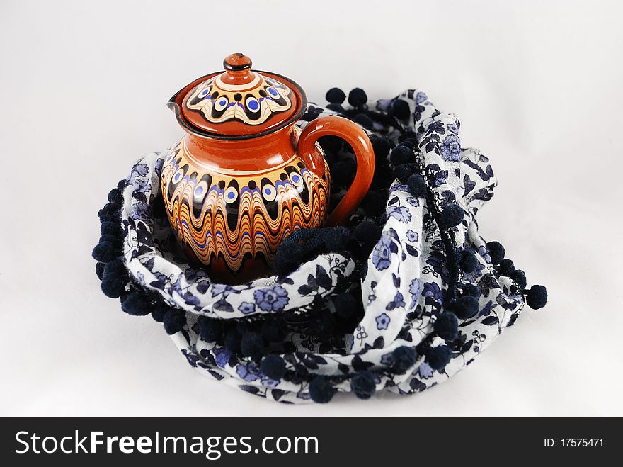 A jug and a shawl on white background