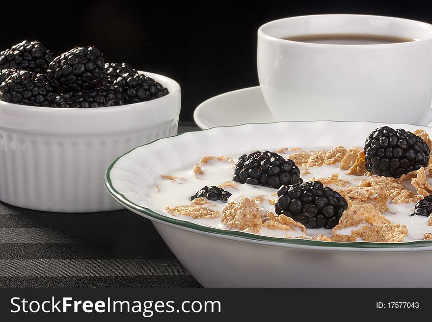 Light morning meal from cereals with berries of a blackberry and milk, in a coffee cup. Light morning meal from cereals with berries of a blackberry and milk, in a coffee cup.