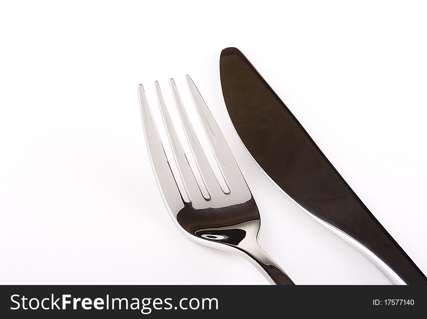 Knife and fork on a white background - tableware.