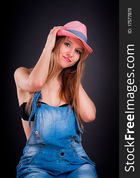 Pretty girl in pink hat and jeans overalls