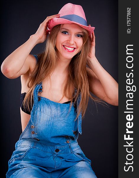 Pretty girl in pink hat and jeans overalls