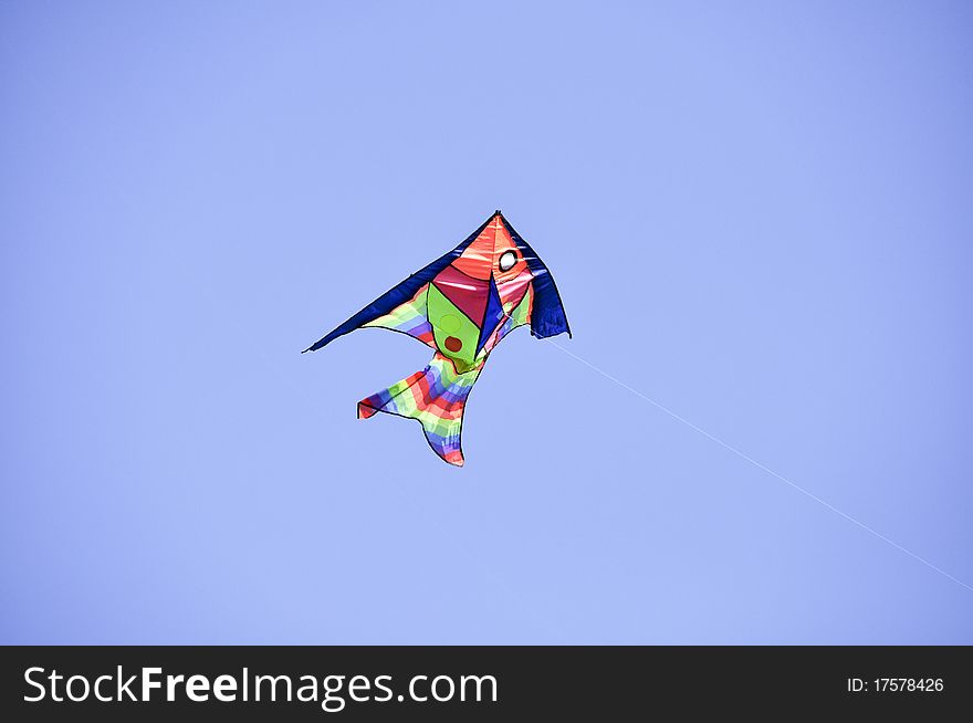 Kite on a string on a background of blue sky