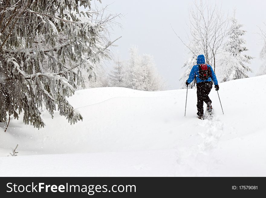 Man with snowshoes in snow covered landscape