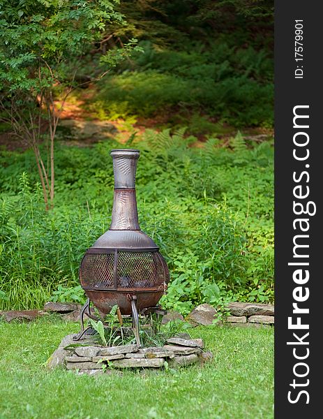 Rustic metal chiminea in the summer backyard