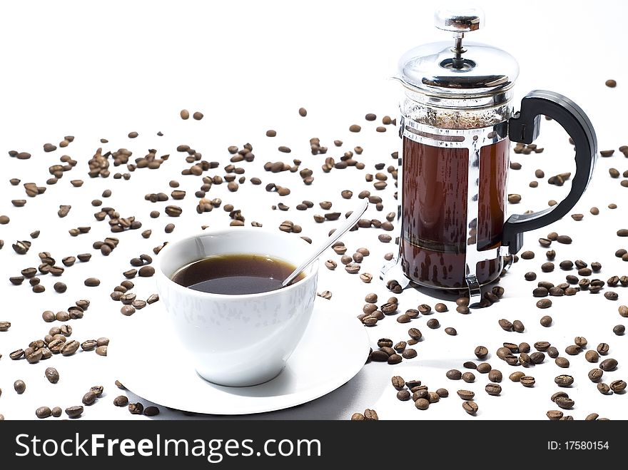 Cup of coffee with beans and coffee maker on white background