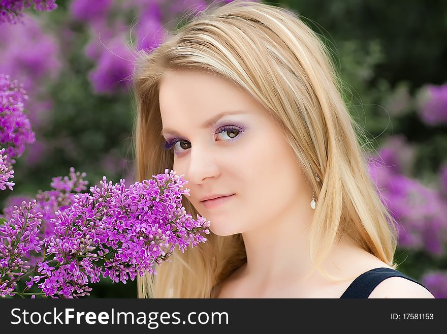 Portrait Of  Blonde Girl Near The Lilacs