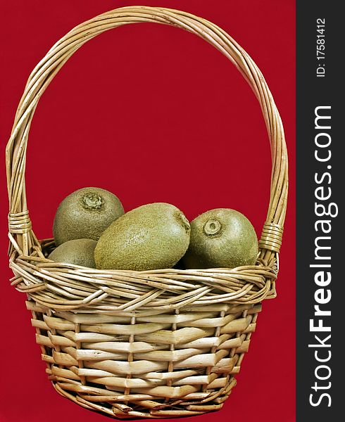 A wicker basket full of ripe kiwi fruit. A wicker basket full of ripe kiwi fruit