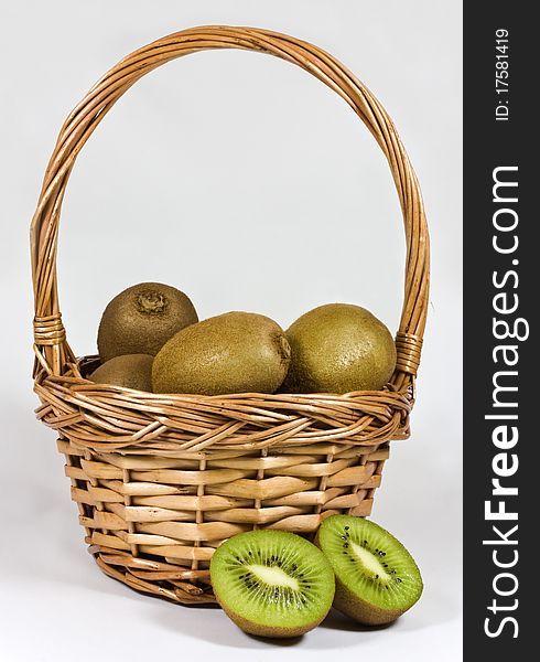 A wicker basket full of ripe kiwi fruit. A wicker basket full of ripe kiwi fruit