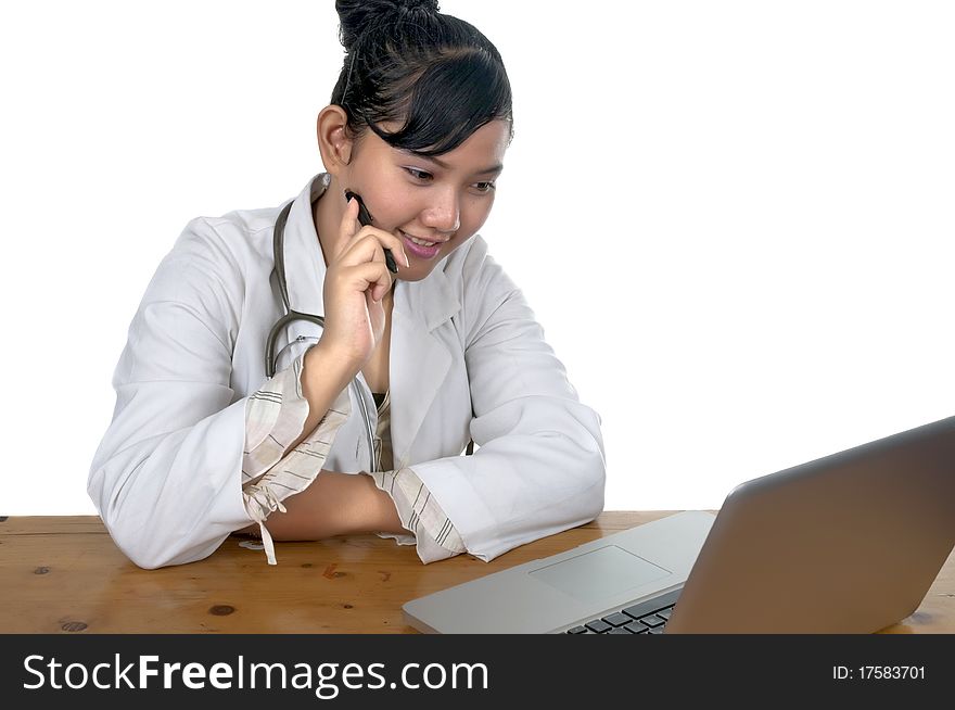 Beautiful young doctor working in front of laptop isolated over white background. Beautiful young doctor working in front of laptop isolated over white background