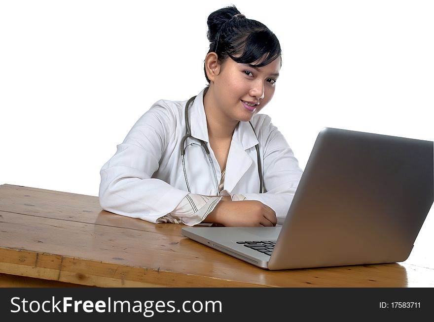 Beautiful young doctor working in front of laptop isolated over white background. Beautiful young doctor working in front of laptop isolated over white background