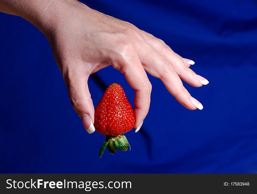 A woman picking up a strawberry. A woman picking up a strawberry