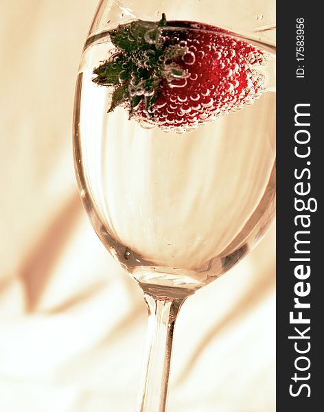 A strawberry in a glass of wine. A strawberry in a glass of wine