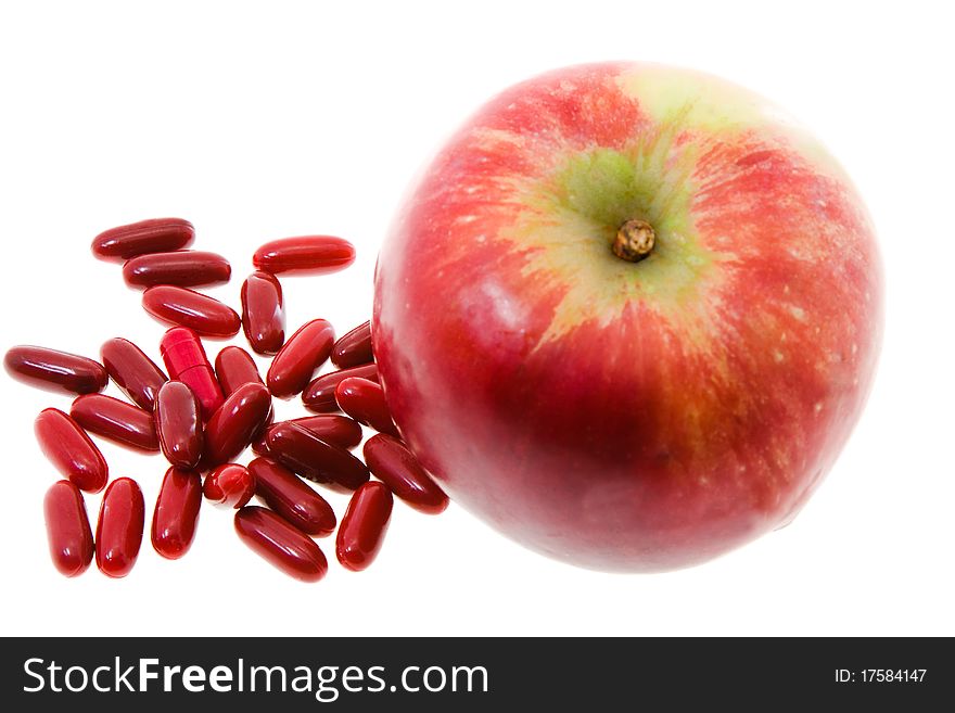 Red apple with red pills (medicines in a red cover, focus on the tablets isolated). Red apple with red pills (medicines in a red cover, focus on the tablets isolated)