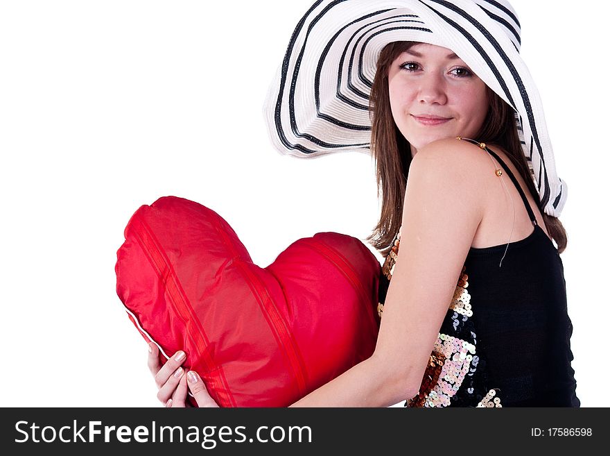 Beautiful young girl sitting on a bar chair with red heart pillow isolated on white