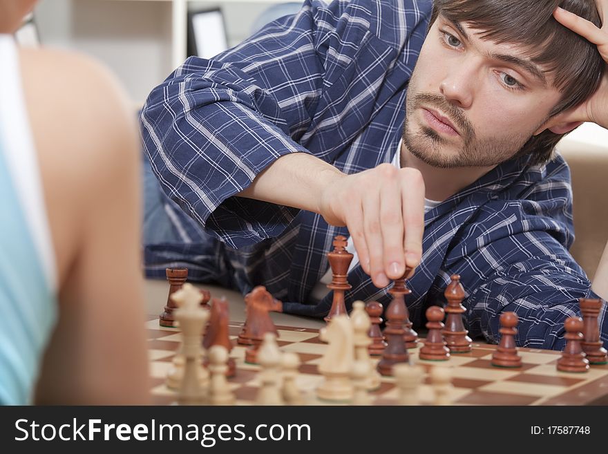 Couple playing chess at home
