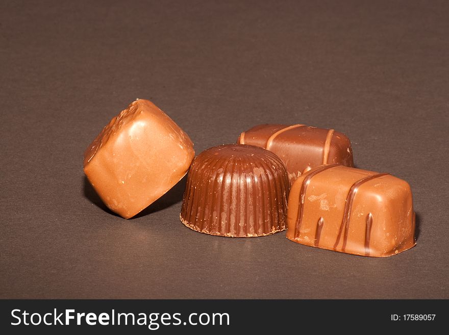 Four chocolates on a black background.