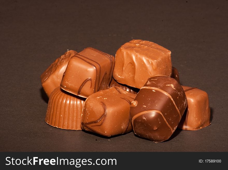 A pile of chocolates on a black background.