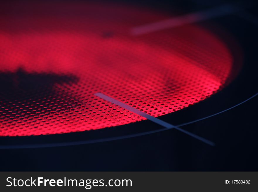 Black background with a red light. Luminescent glass ceramic surface. Black background with a red light. Luminescent glass ceramic surface