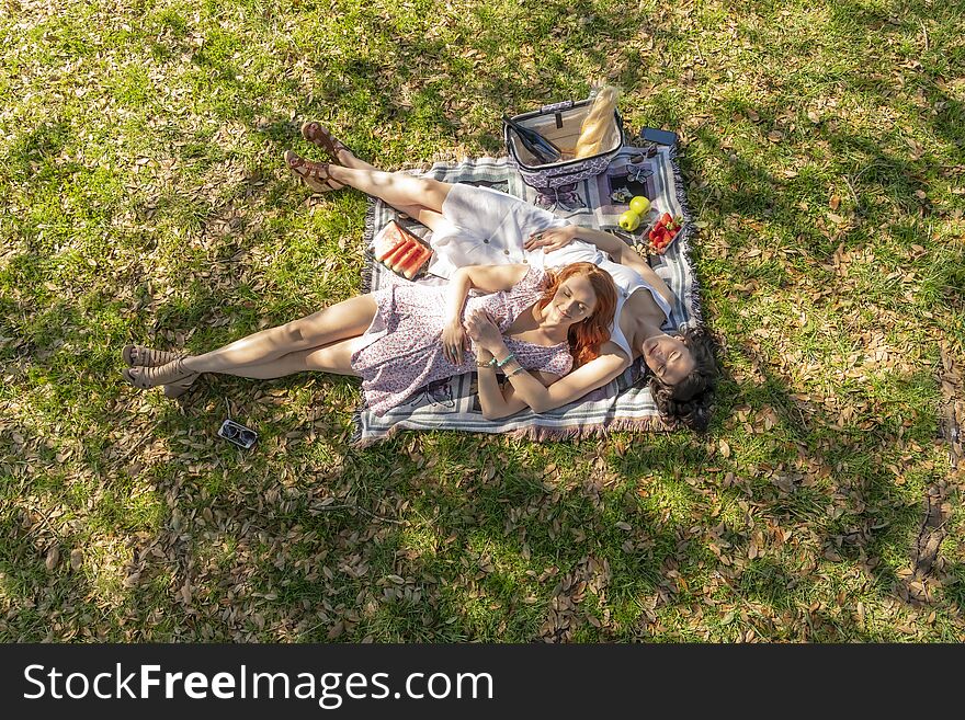 Two gorgeous models enjoying each others company on a fall day with a picnic. Two gorgeous models enjoying each others company on a fall day with a picnic