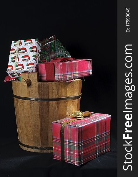 Handcrafted country bucket with full of Christmas  gifts in black background. Handcrafted country bucket with full of Christmas  gifts in black background