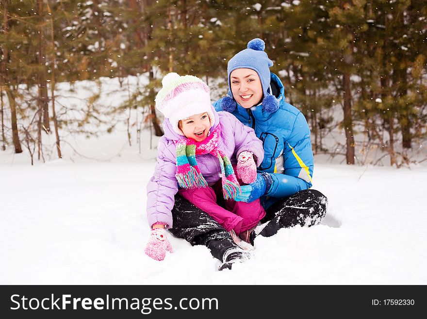 Happy family; young mother and her daughter having fun in the winter park (focus on the child). Happy family; young mother and her daughter having fun in the winter park (focus on the child)