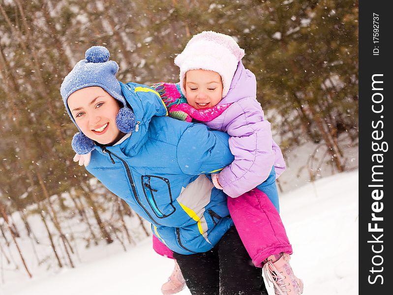 Happy family; young mother and her daughter having fun in the winter park. Happy family; young mother and her daughter having fun in the winter park