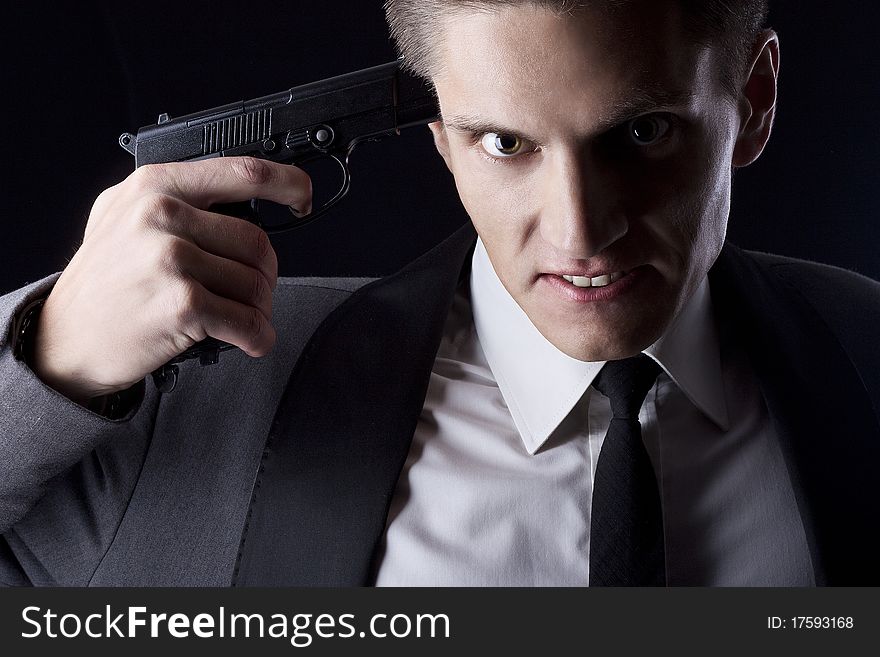 Young attractive macho in suit with gun